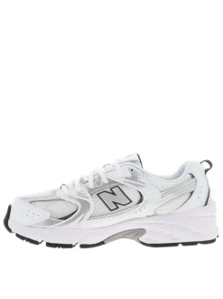 Baskets multisport blanches à talon plat avec une languette d'aisance