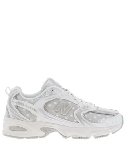 Baskets multisports blanches à pois avec une semelle plate et des lacets plats