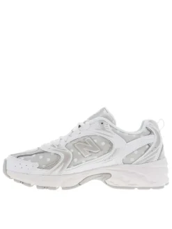 Baskets multisports blanches à pois avec une semelle plate et des lacets plats