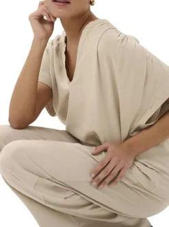 Blouse beige unie pourvue d'un col tunisien et de manches courtes