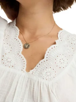 Blouse blanche à coupe droite pourvue d'un col v et de manches courtes