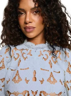Blouse bleu clair à coupe ajustée pourvue d'un col montant et de manches longues