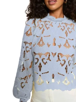 Blouse bleu clair à coupe ajustée pourvue d'un col montant et de manches longues
