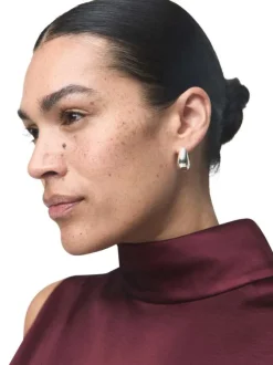 Blouse bordeaux en tissu satiné sans manches pourvue d'un col montant