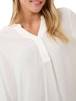 Blouse écrue unie pourvue d'une coupe droite et d'un col tunisien