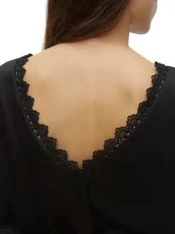 Blouse noire en dentelle à coupe ample col v et à manches longues