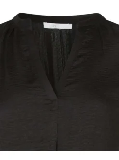 Blouse noire unie avec un aspect satiné une coupe fluide et un col v