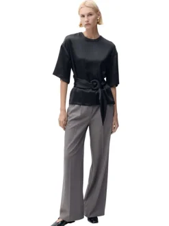 Blouse noire unie avec une coupe droite à col rond et un bouton de fermeture