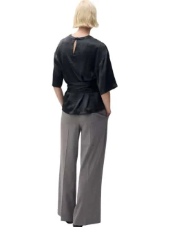 Blouse noire unie avec une coupe droite à col rond et un bouton de fermeture