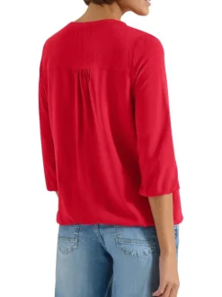 Blouse rouge unie pourvue d'une coupe large et d'un col tunisien