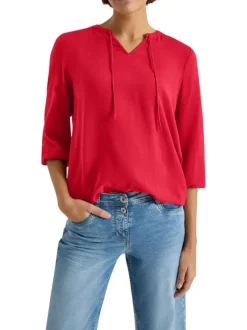 Blouse rouge unie pourvue d'une coupe large et d'un col tunisien