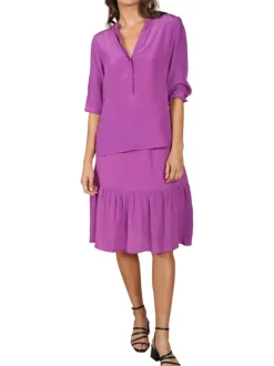 Blouse violette unie coupe droite avec un col tunisien resserré élastiquement à l'extrémité des manches