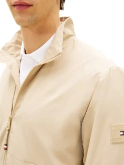 Blouson beige pourvu d'une fermeture zippée ton sur ton et du patch de la marque