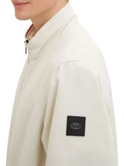 Blouson beige uni coupe droite avec un col montant et des poches latérales