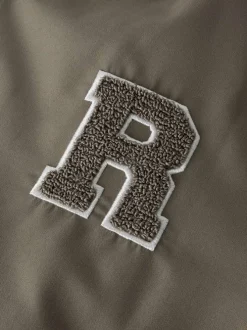 Bomber beige uni pourvu d'une coupe droite et d'un col montant
