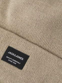 Bonnet beige uni avec un petit patch noir brodé sur le devant et un revers