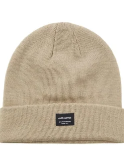 Bonnet beige uni avec un petit patch noir brodé sur le devant et un revers