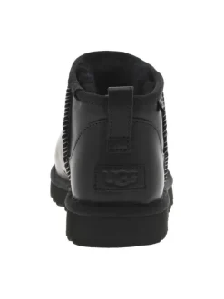 Boots en cuir noires à talon plat avec des surpiqûres noires et blanches