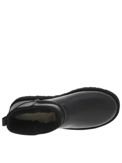 Boots en cuir noires à talon plat avec des surpiqûres noires et blanches