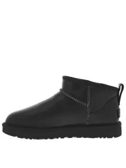 Boots en cuir noir mat à talon plat avec une semelle cranté et à slip-on
