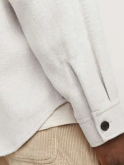 Chemise écrue unie avec une coupe droite un col à revers et des manches longues