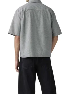 Chemise en coton blanche et noire unie avec une coupe droite et un col à revers
