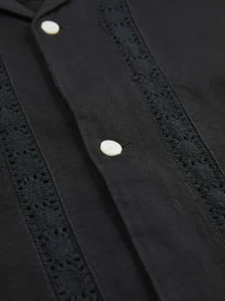 Chemise noire unie avec une coupe droite à col français et des boutons