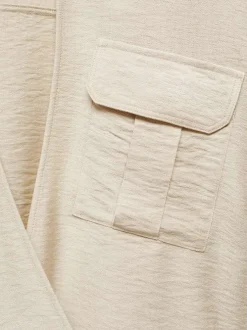 Chemisier beige uni avec une coupe droite et un col v à manches longues