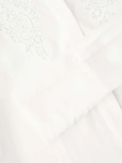 Chemisier blanc uni avec une coupe droite et un motif floral ajouré