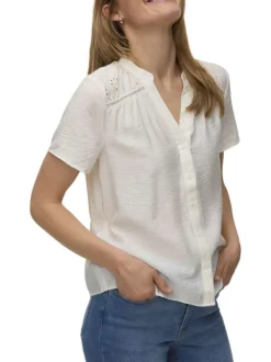 Chemisier blanc uni pourvu de détails en dentelle sur les épaules