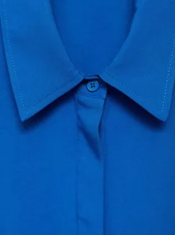 Chemisier bleu uni avec une coupe large un col français et à manches longues