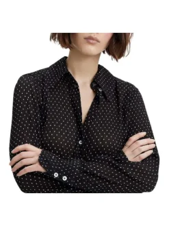 Chemisier noir transparent avec un imprimé à pois blancs et des manches longues