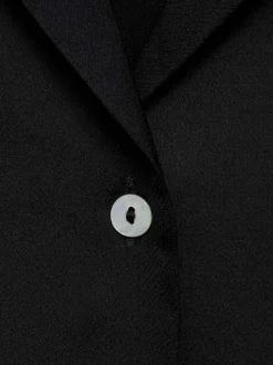 Chemisier noir uni avec un col à revers et une fermeture boutonnée