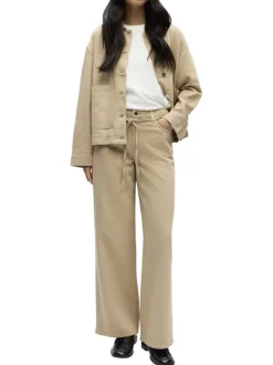Jean beige uni pourvu d'une coupe bootcut et d'un lien à nouer à la taille