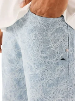 Jean bleu ciel brodé à motif cachemire avec une fermeture zippée