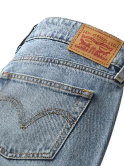 Jean bleu clair uni avec une coupe bootcut et multiples poches plaquées
