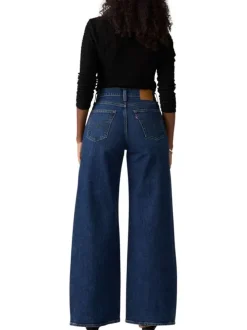 Jean bleu uni avec une coupe bootcut et multiples poches plaquées