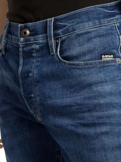 Jean en coton bleu avec des passants pour ceinture et une coupe slim