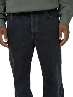 Jean en coton noir légèrement délavé avec une coupe baggy et des passants