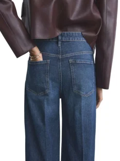 Jean 5 poches en coton indigo légèrement délavé avec une coupe bootcut