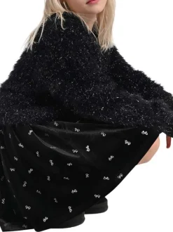 Jupe courte noire unie en velours avec une coupe plissée et nœuds brodés