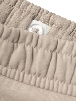 Pantalon beige uni avec une coupe slim et des poches latérales