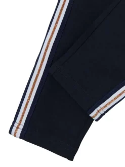 Pantalon marine style jogging avec une coupe slim et liseré en lurex doré