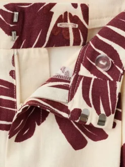 Pantalon beige à motifs pourvu d'une coupe large et de détails plissés