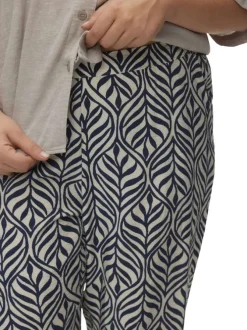 Pantalon blanc et bleu marine à motif tropical avec une coupe bootcut