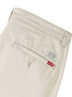 Pantalon chino en coton beige coupe ample pourvu du patch de la marque