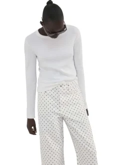 Pantalon en coton blanc à pois pourvu de passants pour la ceinture