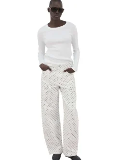 Pantalon en coton blanc à pois pourvu de passants pour la ceinture