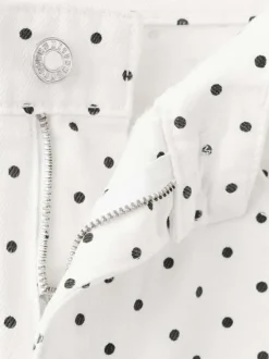 Pantalon en coton blanc à pois pourvu de passants pour la ceinture