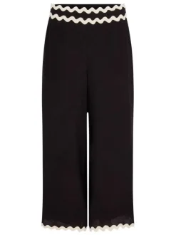 Pantalon noir uni pourvu de finitions festonnées contrastées